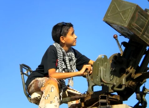 Boy with a video camera in the heart of conflict