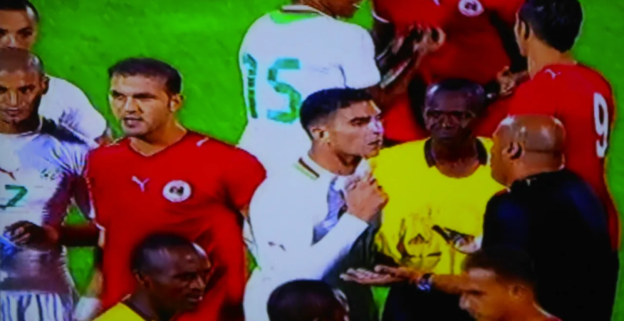 The referee and some Algerian players as they try to convince Albrich (Libya’s coach) and the Libyan players not to leave the field following abusive and intimidating chants from the Algerian crowd. (Photo: Mohamed Assed)