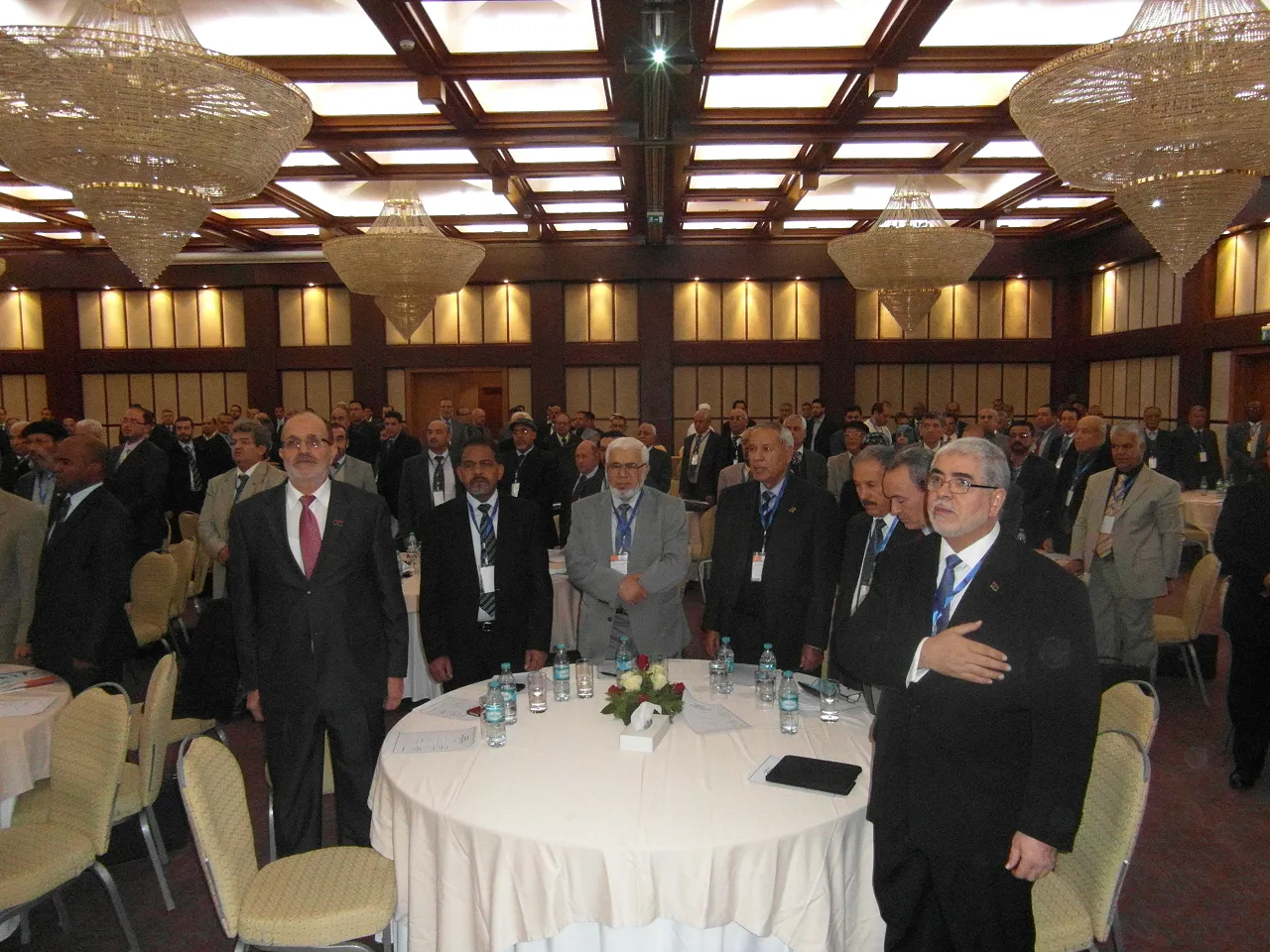 SAM_1120 Ex Industry Minister Mohamed Fetesie (left) and ex First Deputy Prime Minister Mustafa Abushagur (front right) upstanding for the national anthem at the NPC conference (Photo: Sami Zaptia).