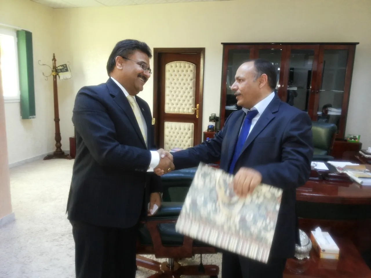 Agriculture Minister Saleh Hamed Mahjoub shakes hands with the Indian Ambassador