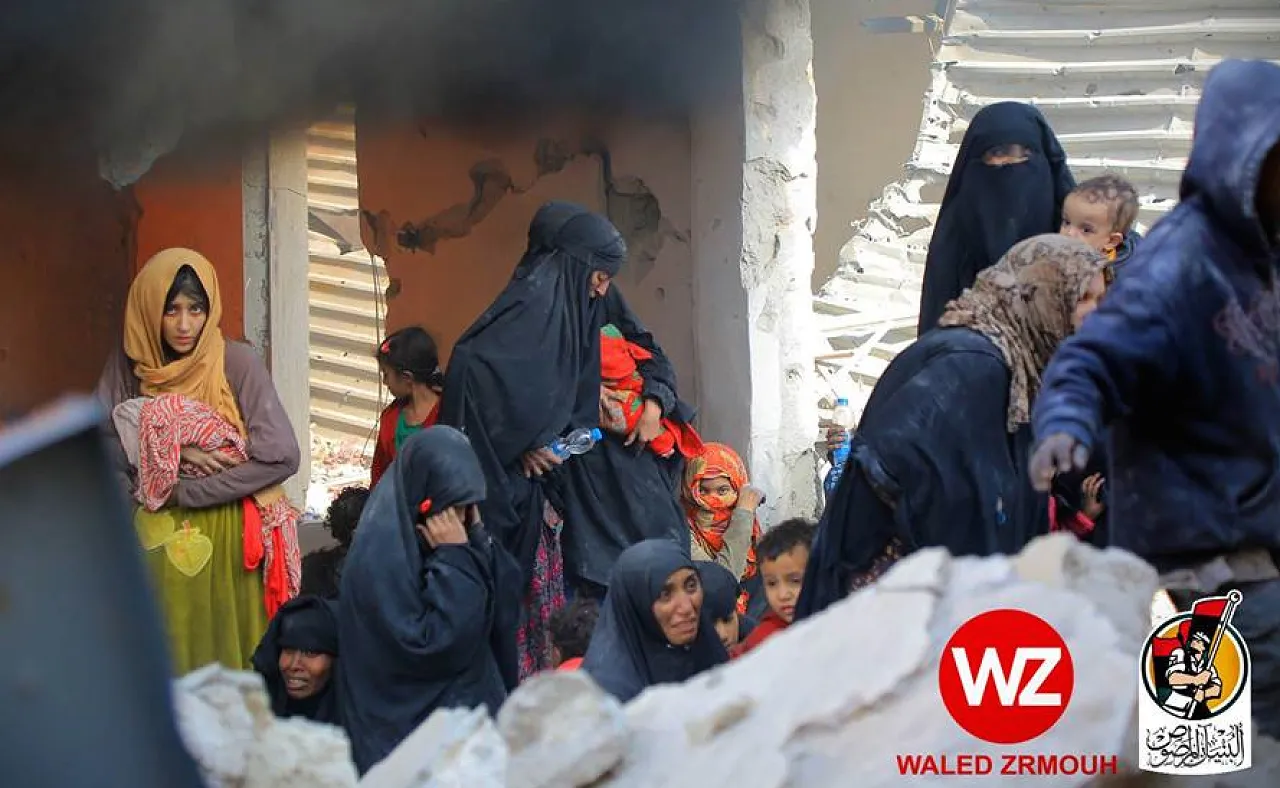 The fearful faces of defeat. Women with children flee over the rubble (Photo: