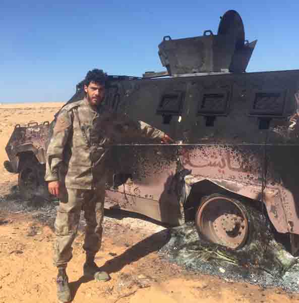 LNA soldier beside a wrecked BDB personnel carrier (Photo: social media)