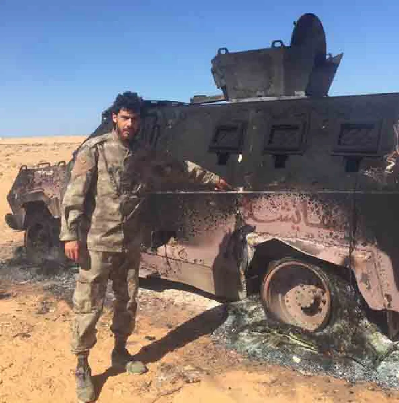 LNA soldier beside a wrecked BDB personnel carrier (Photo: social media)