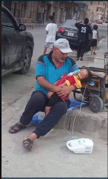 The original photo widely circulating on Libyan social media with a father plugging his child's breathing machine to a street curb generator (Photo: Social media).